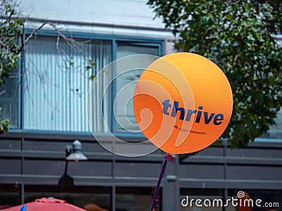 Orange Kaiser Permanente thrive balloon flying in an urban area Editorial Stock Photo