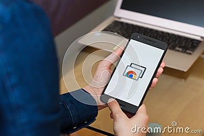 SAN FRANCISCO, US - 22 April 2019: Close up to female hands holding smartphone using Chrome Remote Desktop application, San Editorial Stock Photo