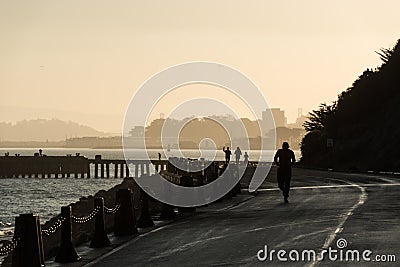 SAN FRANCISCO, USA - OCTOBER 12, 2018: People running at sunrise near Torpedo Wharf and Fort Point San Francisco Editorial Stock Photo