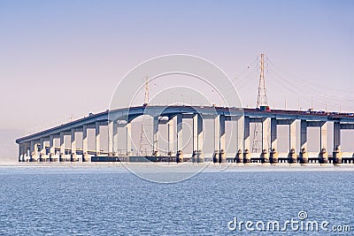 San Mateo Bridge connecting the Peninsula and East Bay in San Francisco Bay Area, California; Electricity towers and power lines Stock Photo