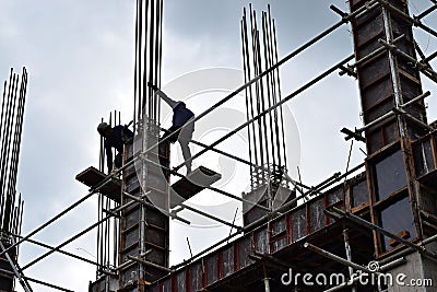 Filipino construction steel-men working joining column steel pieces on board scaffolding pipes on high-rise building Editorial Stock Photo