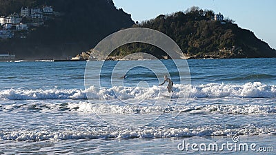 San Sebastian, Spain - December 30, 2017: Lonely surfer is surfi Editorial Stock Photo