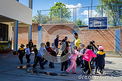 Yungay, Peru, July 14, 2014: San Viator schoolyard with young children playing together with the teacher and cooperators around h Editorial Stock Photo