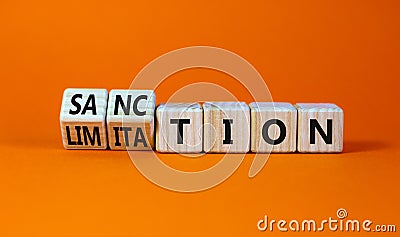 Sanction and limitation symbol. Turned wooden cubes and changed the word limitation to sanction. Beautiful orange table, orange Stock Photo