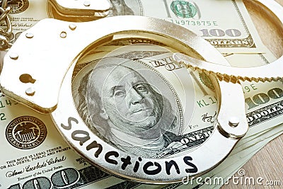 Sanctions on a handcuffs and American dollar bills. Economical restrictive measures. Stock Photo