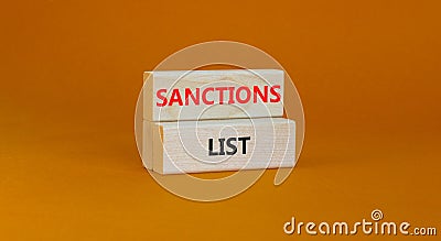 Sanctions list symbol. Wooden blocks with concept words Sanctions list on beautiful orange background. Business political Stock Photo