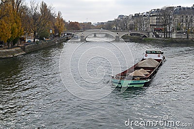 Sand and asphalt transport on flat riverboat on Seine river in Paris France Editorial Stock Photo