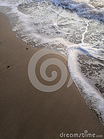 sand beach and sea waves top view. Soft wave and sunny sand shore. Vertical photo. Stock Photo