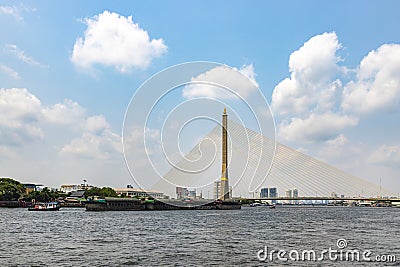 Sand boats are sailing along the Chao Phraya River. Bangkok's main river going through the Rama VIII Bridge in the daytime Editorial Stock Photo