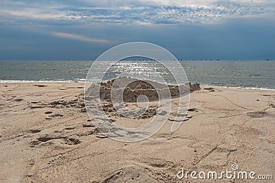 Sand castle on the beach against the background of a pre-sunset summer sky. Summer fun and games Stock Photo