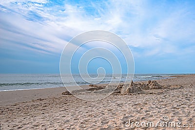 Sand castle on the beach against the background of a pre-sunset summer sky. Summer fun and games Stock Photo