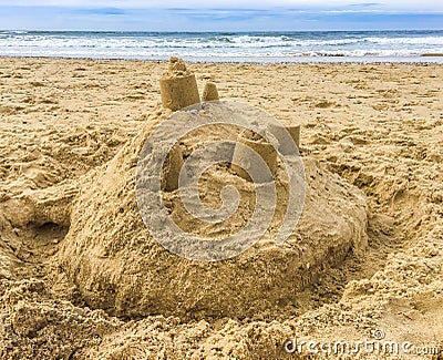 Sand castle building with towers on the beach with view on the sea Stock Photo