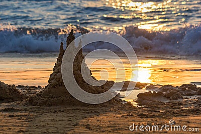 Sand castle is in sunset. Solar track is in the sand. Background Stock Photo