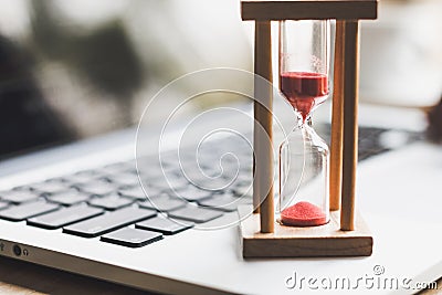 Sand clock timer on laptop .symbol of time Stock Photo