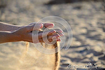 Sand pours out of the hands Stock Photo