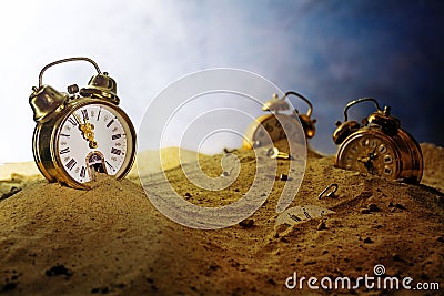 Sand running out of an alarm clock, other watches sink into the Stock Photo