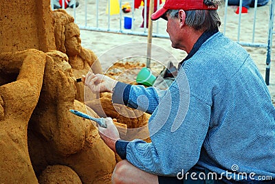 A sand sculptor carving the details Editorial Stock Photo