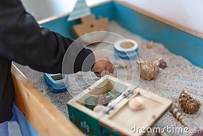 Sand therapy. The child is built in a sandbox world Stock Photo