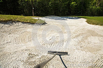 Sand trap, rake in a golf course sand bunkers, raking the sand Stock Photo