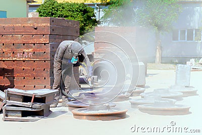 Sandblasting at an industrial plant, a worker knocks down oxide Stock Photo