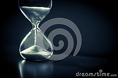 A sandglass, modern hourglass or egg timer with shadow showing the last second or last minute or time out. Stock Photo