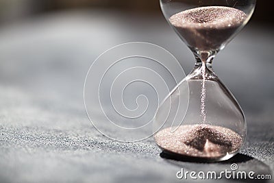 A sandglass, modern hourglass or egg timer with shadow showing the last second or last minute or time out. Stock Photo