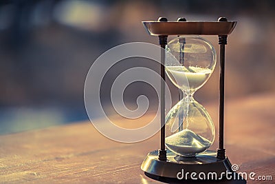 A sandglass, modern hourglass or egg timer with shadow showing the last second or last minute or time out. Stock Photo