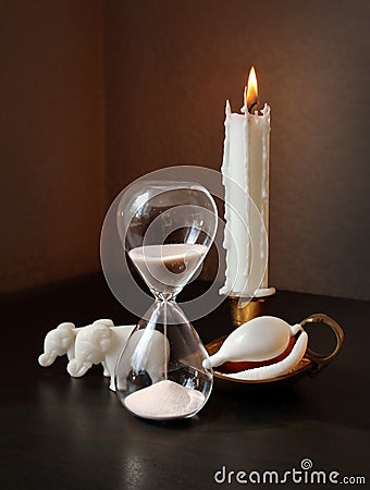 Sandglass, two toy elephants and white shell Stock Photo