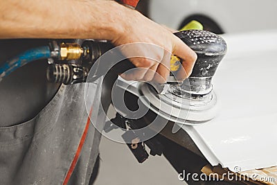 Sanding of uneven elements of the car after painting and varnishing. Vehicle repair in service station. Stock Photo