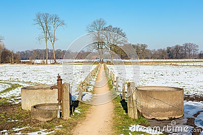 Sandpath and water well in snowy dutch landscape Stock Photo