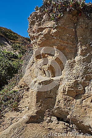 Sandstone cliff with Pirate Skull on beach Stock Photo