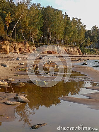 Sandstone cliffs on the seashore, beautiful reflections in the water Stock Photo