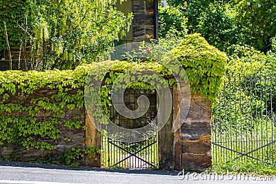 Sandstone portal with lattice gate and ivy Stock Photo