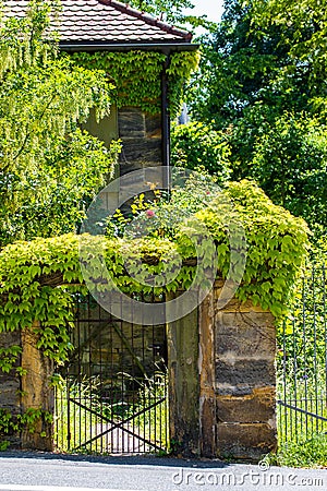 Sandstone portal with lattice gate and ivy Stock Photo