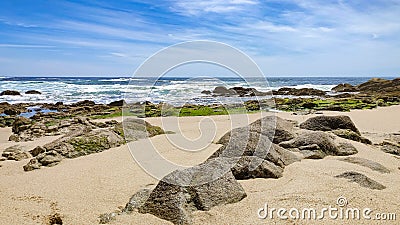 Sandstone rocks jutting from sand on beach in Povoa De Varzim, Portugal. Stock Photo