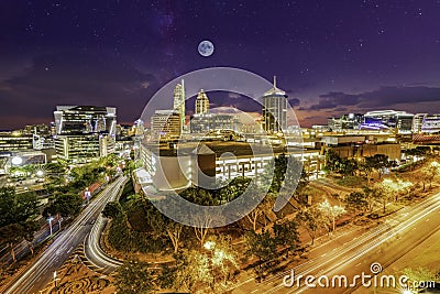 Sandton City at night illuminated buildings with moon and stars in the sky Stock Photo