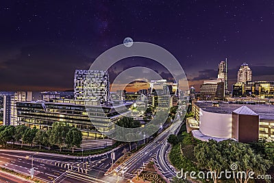 Sandton City skyline lit up at night with moon and stars in the sky Stock Photo