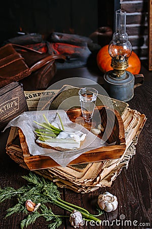 A sandwich of black bread and lard, lying on a tray of the tavern. Garlic, dill, a shot of vodka. Traditional Ukrainian snack Stock Photo