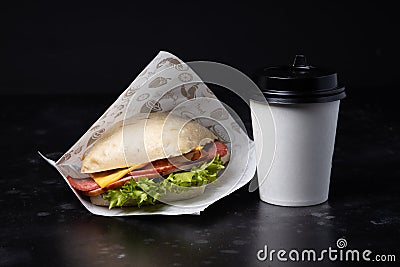 Sandwich and coffee on the black background. Fastfood. Burgeer. Stock Photo