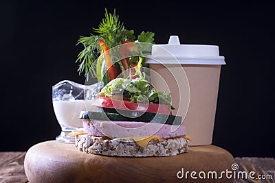 Sandwich with ham, chopped vegetables and sauce and a cup of coffee on a wooden tray. Stock Photo