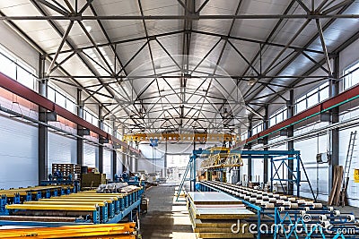 Sandwich manufactory panel production line. Equipment machine tools and roller conveyor in large hangar or workshop Stock Photo