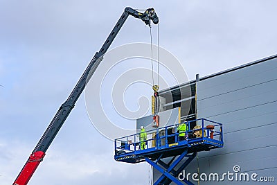 Sandwich panels wall mounting using crane and scissor lift Stock Photo