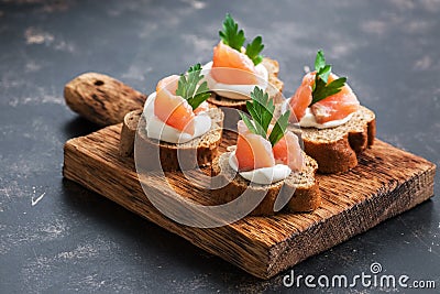 A sandwich with red fish, soft cheese and parsley on rye bread. Selective focus Stock Photo