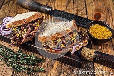 Sandwich with slow smoked pulled pork meat on white bread. wooden background. Top view Stock Photo