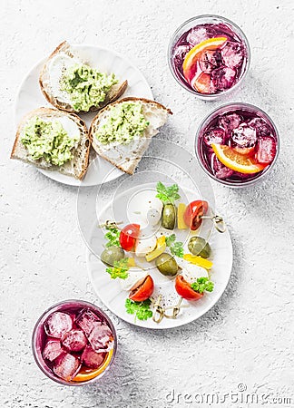 Sandwiches with avocado, canape with mozzarella, tomatoes, olives and aperol spritz Stock Photo