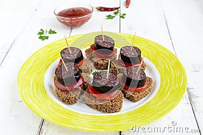 Sandwiches with black rye bread in the shape of a heart, blood sausage Morcillo and pieces of sweet pepper on skewer Stock Photo