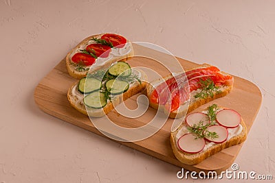 Sandwiches with trout pieces, avocado, radishes. Perfect for breakfast. On a concrete and white background. Stock Photo