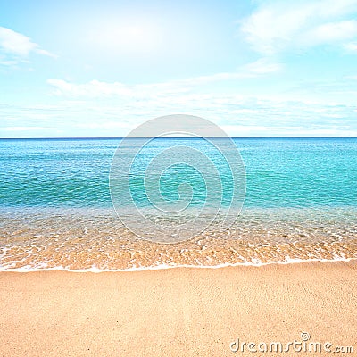 Sandy beach with calm water against blue skies. Stock Photo