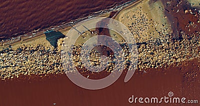 Sandy beach with with colourful sea waves splashing. Birds flying over sea. Stock Photo