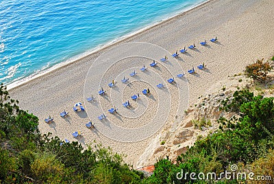 Sandy beach with empty sunbeds from above Stock Photo